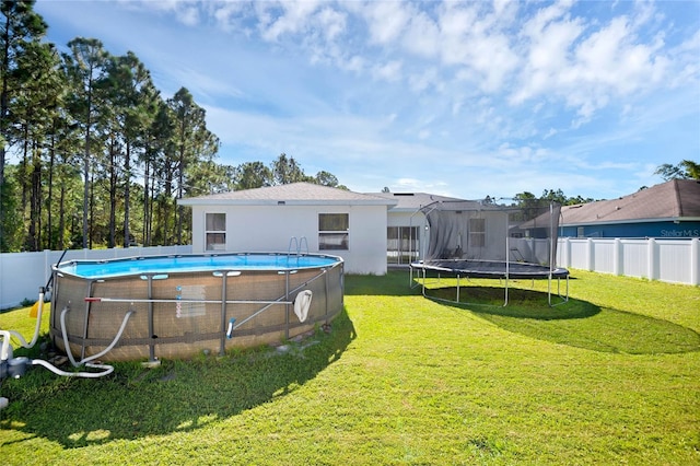 view of yard with a fenced in pool and a trampoline