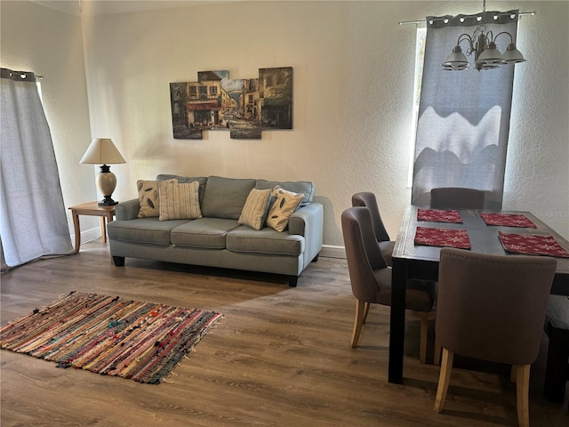 living room with wood-type flooring and a notable chandelier