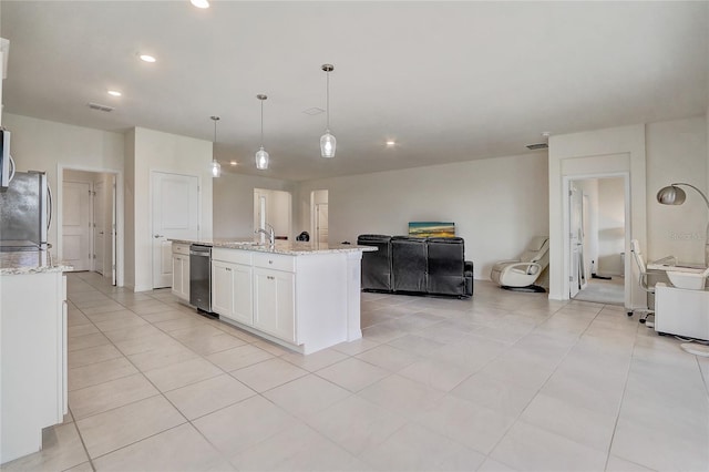 kitchen with white cabinetry, stainless steel appliances, light stone counters, pendant lighting, and a center island with sink