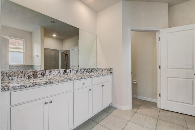 bathroom featuring tile patterned floors, a shower with door, and vanity