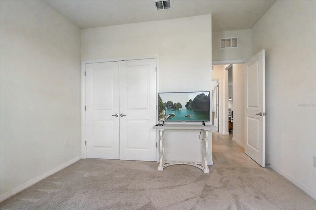 7889 Penrose Pl, Wildwood, FL 34785 - unfurnished bedroom with light carpet, baseboards, and a closet