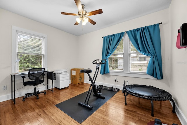 exercise room with hardwood / wood-style floors, a healthy amount of sunlight, and ceiling fan