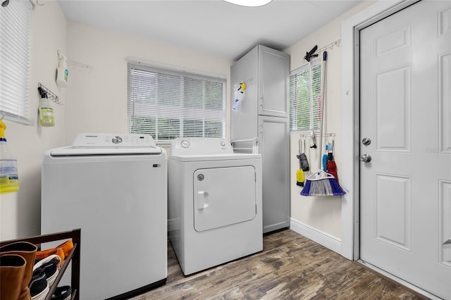 washroom featuring dark hardwood / wood-style flooring, cabinets, and washing machine and clothes dryer