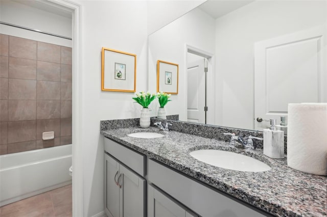 full bathroom featuring tile patterned flooring, vanity, tiled shower / bath combo, and toilet