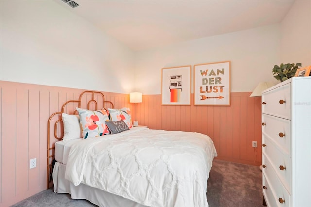 bedroom with wooden walls and carpet flooring