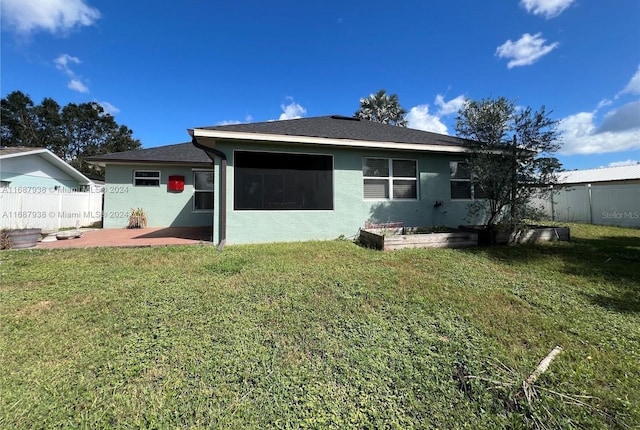 rear view of property with a patio and a yard