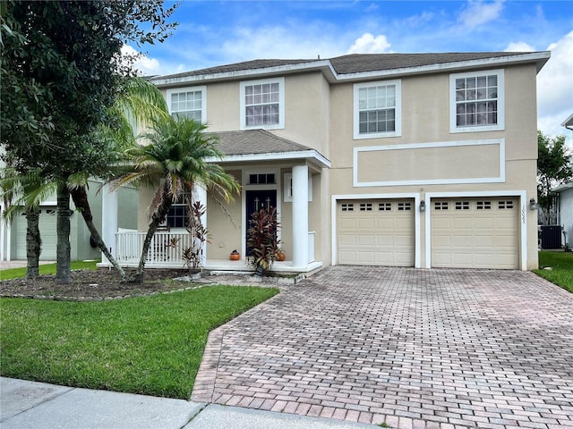 view of front facade with a garage, cooling unit, covered porch, and a front lawn