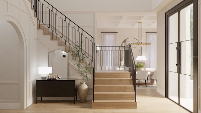 stairs featuring hardwood / wood-style flooring, coffered ceiling, and beamed ceiling