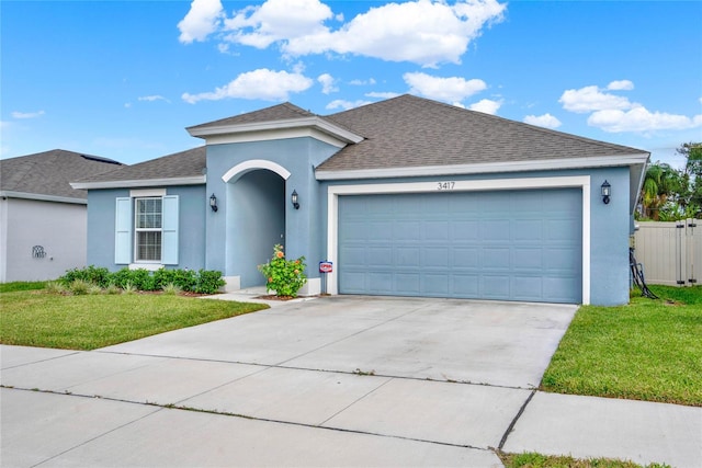 ranch-style home with a garage and a front lawn