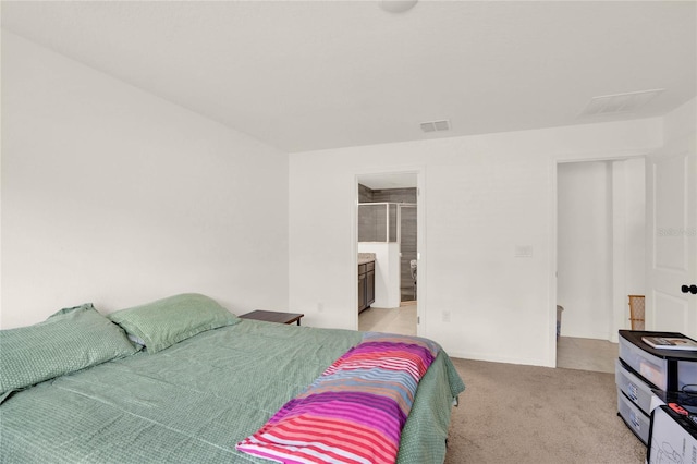 bedroom featuring light colored carpet and ensuite bath