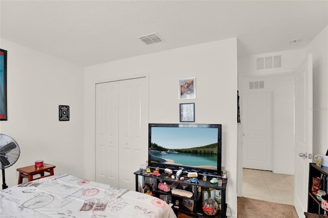 bedroom with a closet and light tile patterned flooring