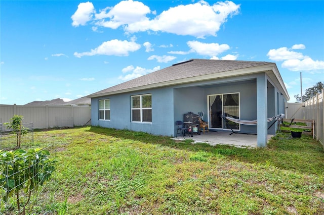 rear view of house featuring a yard and a patio area