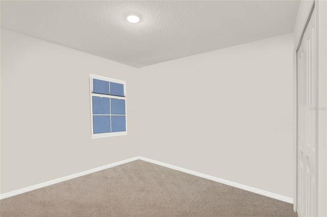 empty room with a textured ceiling and carpet floors