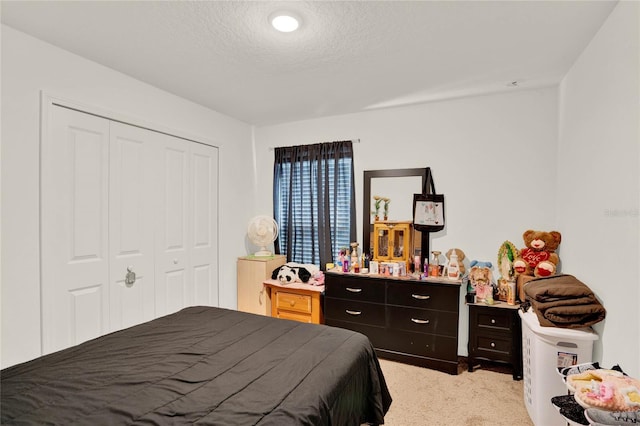 bedroom featuring light carpet, a closet, and a textured ceiling