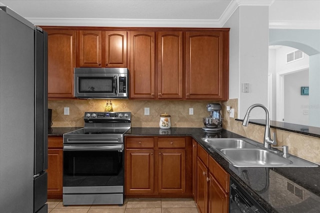 kitchen with stainless steel appliances, light tile patterned floors, tasteful backsplash, sink, and crown molding