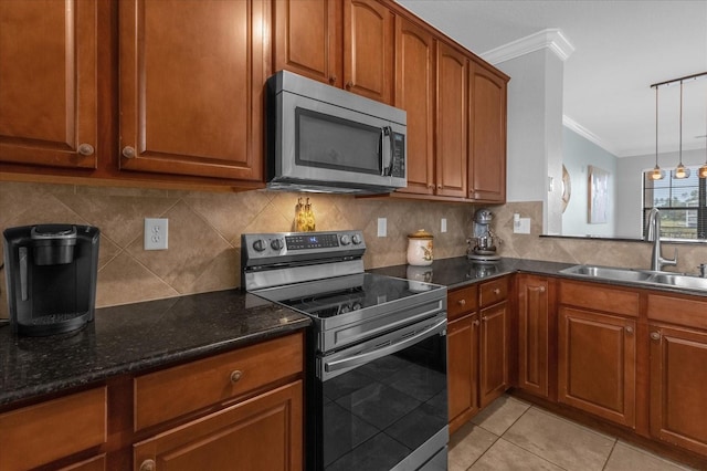 kitchen featuring dark stone counters, sink, light tile patterned floors, crown molding, and appliances with stainless steel finishes