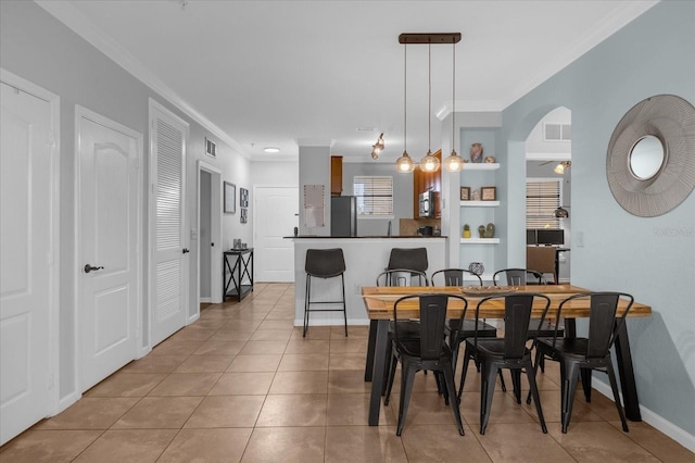 dining area featuring ornamental molding and light tile patterned floors