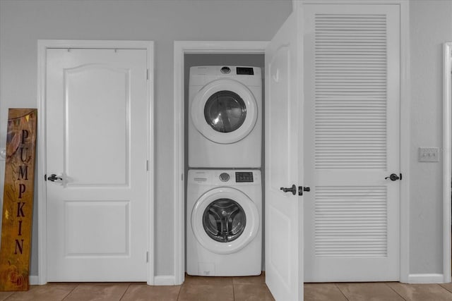 washroom with light tile patterned floors and stacked washer and clothes dryer