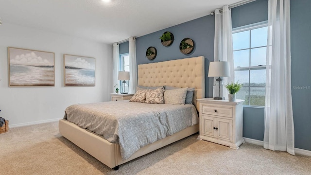 bedroom featuring light colored carpet and multiple windows