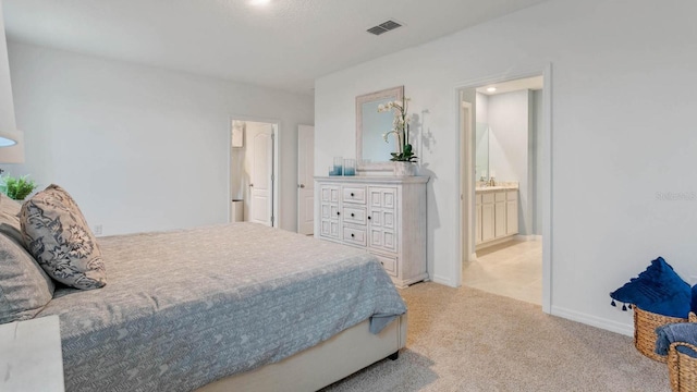 carpeted bedroom featuring ensuite bath