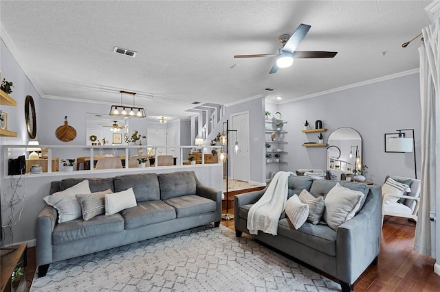 living room with a textured ceiling, hardwood / wood-style floors, ceiling fan, and crown molding