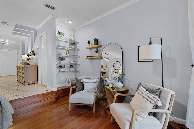 sitting room with ornamental molding and wood-type flooring