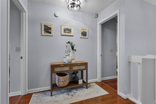 corridor featuring hardwood / wood-style floors and a textured ceiling