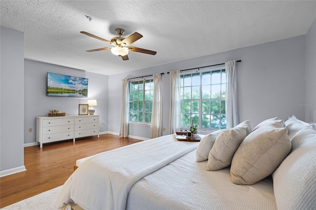 bedroom featuring a textured ceiling, hardwood / wood-style flooring, and ceiling fan