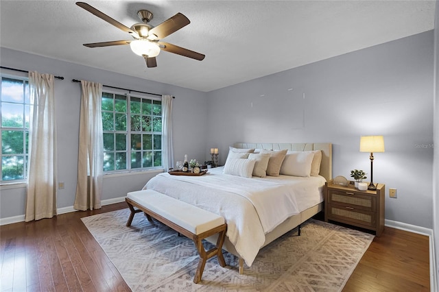 bedroom with hardwood / wood-style floors, ceiling fan, and a textured ceiling