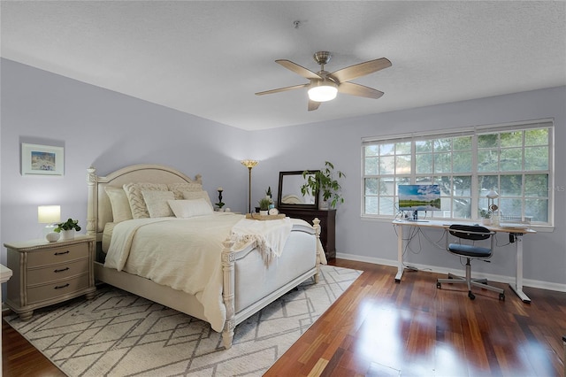 bedroom featuring hardwood / wood-style flooring, ceiling fan, and a textured ceiling