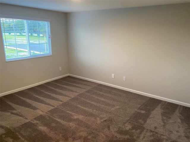 unfurnished room featuring dark carpet