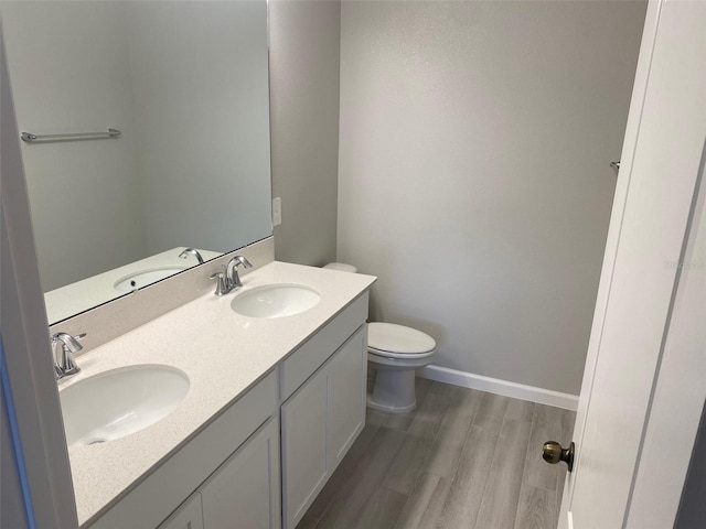 bathroom with toilet, vanity, and hardwood / wood-style flooring