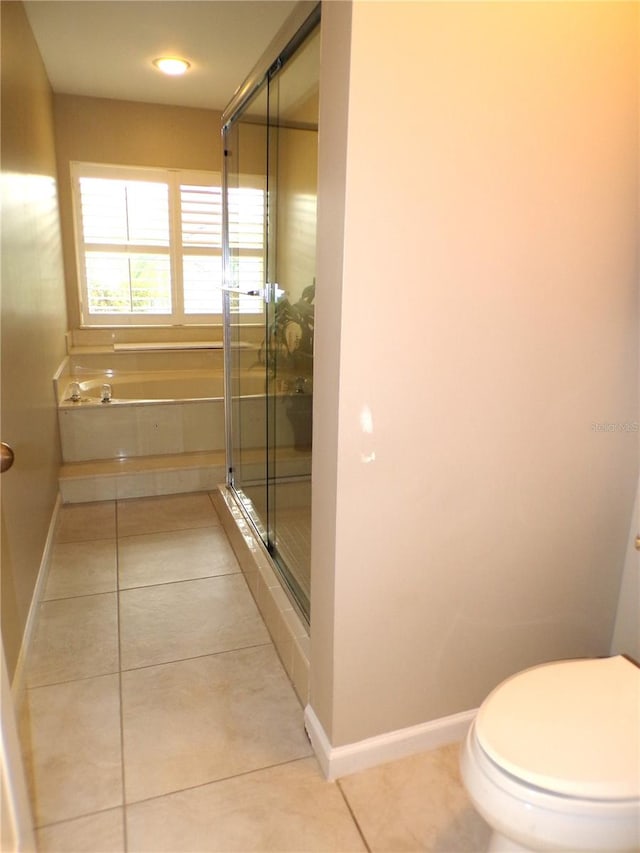 bathroom featuring a shower with door, tile patterned flooring, and toilet