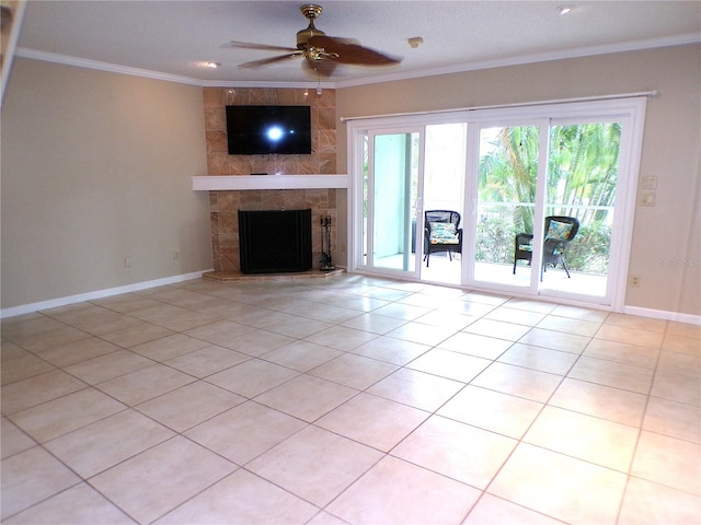 unfurnished living room with ornamental molding, a tiled fireplace, ceiling fan, and light tile patterned floors