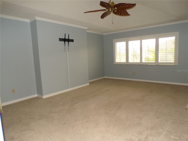 carpeted spare room with ornamental molding, a wealth of natural light, and ceiling fan