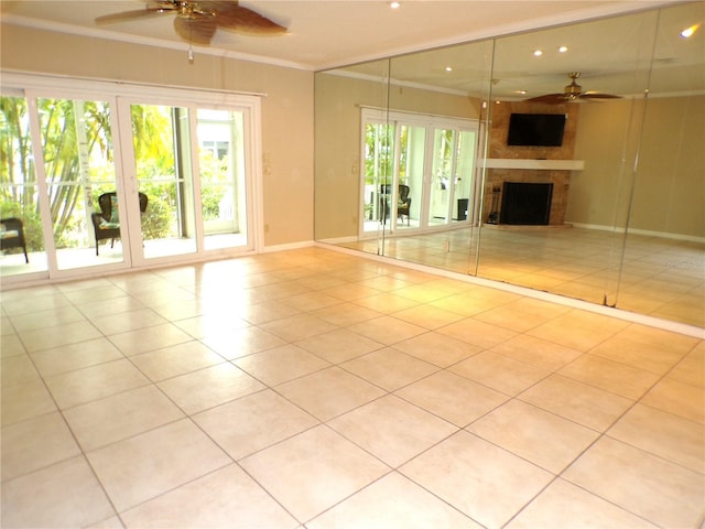 unfurnished living room with ornamental molding, light tile patterned floors, ceiling fan, and a fireplace