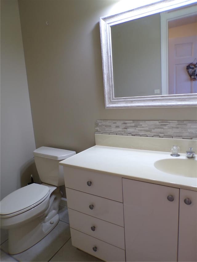 bathroom featuring tile patterned flooring, vanity, and toilet