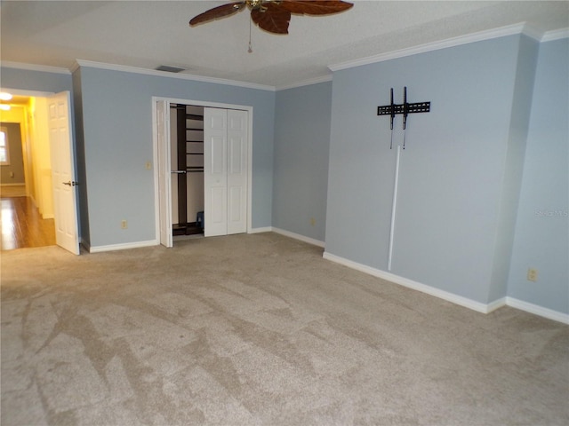 unfurnished bedroom featuring a closet, ceiling fan, light colored carpet, and ornamental molding