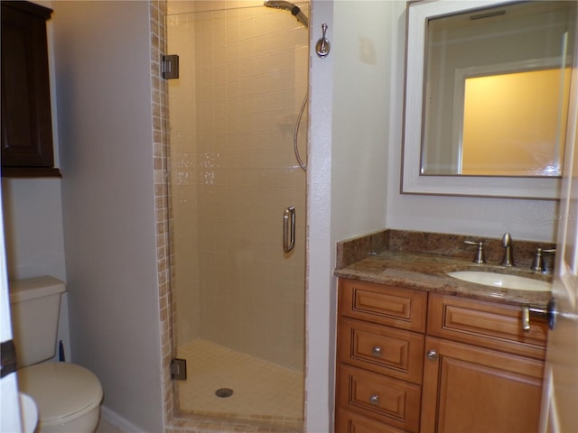 bathroom with walk in shower, vanity, and toilet