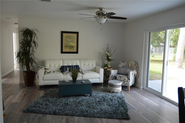 living room featuring plenty of natural light, ceiling fan, and dark hardwood / wood-style flooring