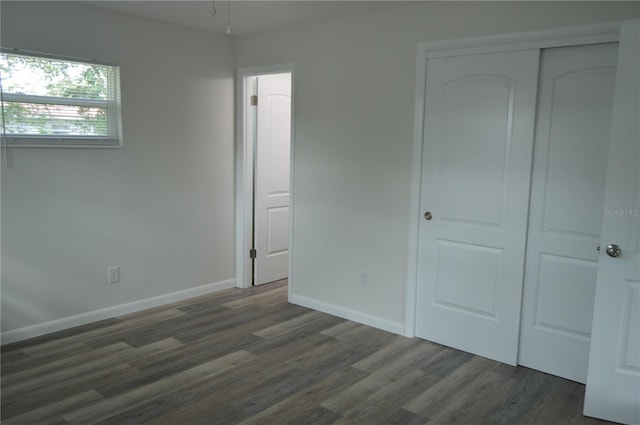 unfurnished bedroom with a closet and dark hardwood / wood-style flooring