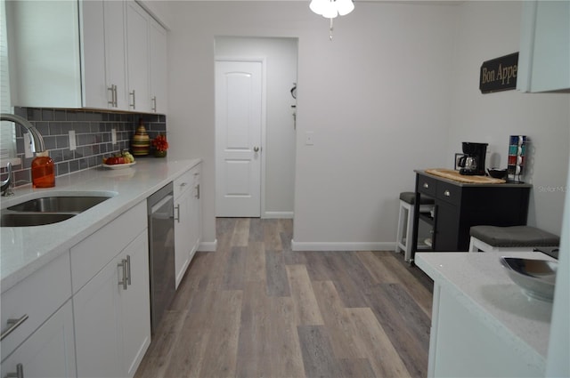 kitchen with white cabinets, light hardwood / wood-style flooring, sink, and dishwasher