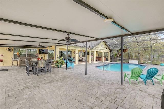 indoor pool featuring ceiling fan, a patio area, outdoor dining space, and a lanai