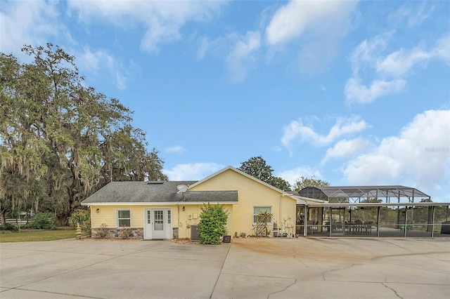 view of front of property with a carport, driveway, a lanai, cooling unit, and stucco siding