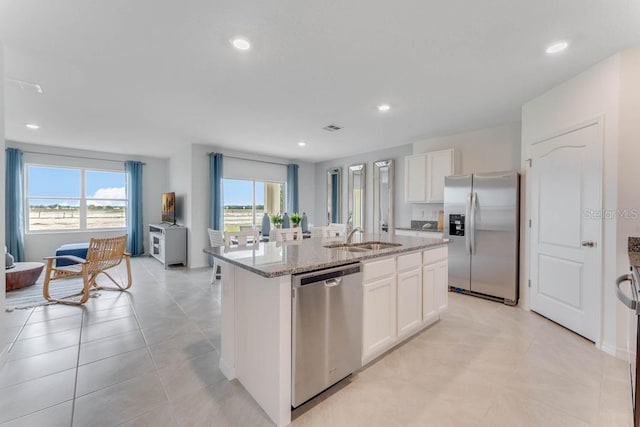 kitchen featuring a kitchen island with sink, sink, stainless steel appliances, and white cabinets