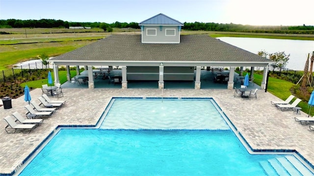 view of swimming pool with a gazebo, a water view, exterior bar, and a patio