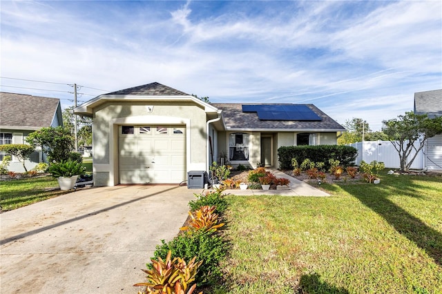 ranch-style home with solar panels, a garage, and a front lawn