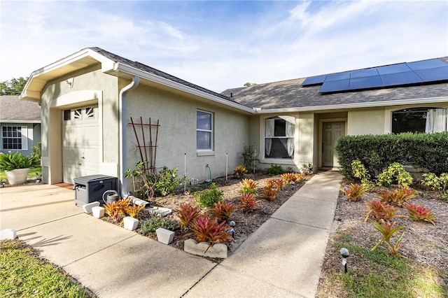 view of front of home with ac unit, solar panels, and a garage