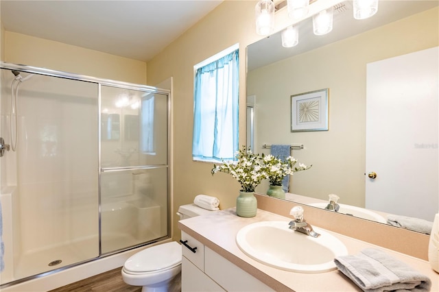 bathroom with vanity, toilet, hardwood / wood-style floors, and an enclosed shower