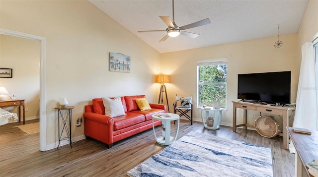 living room featuring vaulted ceiling, ceiling fan, and hardwood / wood-style flooring